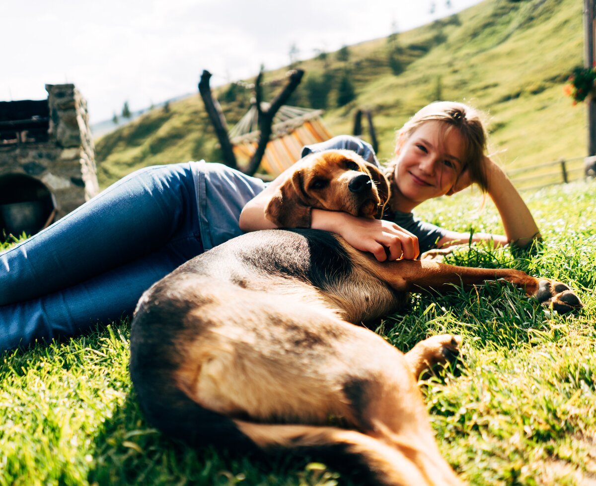 Mädchen und Hund in der Wiese | © Urlaub am Bauernhof Kärnten / Daniel Gollner