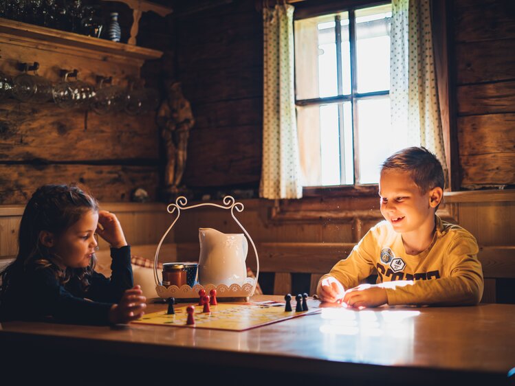 Zwei Kinder spielen ,Mensch ärger dich nicht`in der Almhütte | © Urlaub am Bauernhof Salzburg / Daniel Gollner 