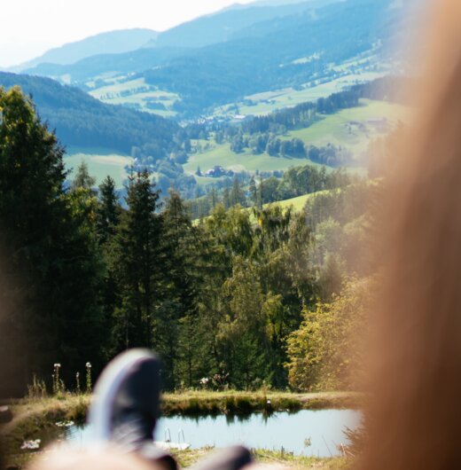 Blick auf Hügel in der Steiermark mit zwei Personen im Vordergrund  | © Urlaub am Bauernhof Steiermark / Daniel Gollner