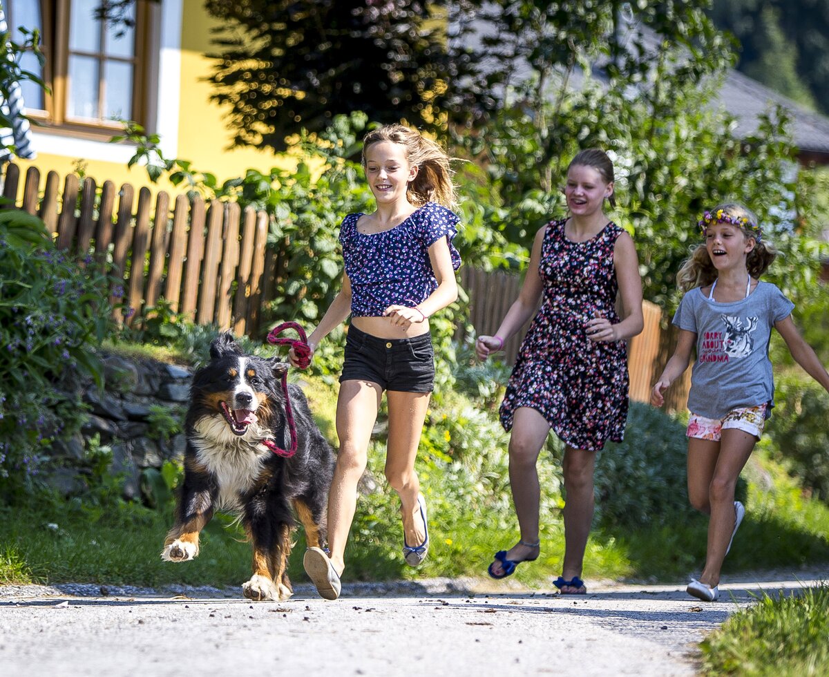 Kinder laufen mit Hund an der Leine über die Straße | © Urlaub am Bauernhof Kärnten / Tom Lamm