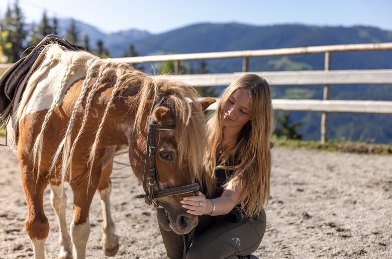 Mädchen streichelt das Pony im Viereck | © Urlaub am Bauernhof Kärnten/ Achim Mandler