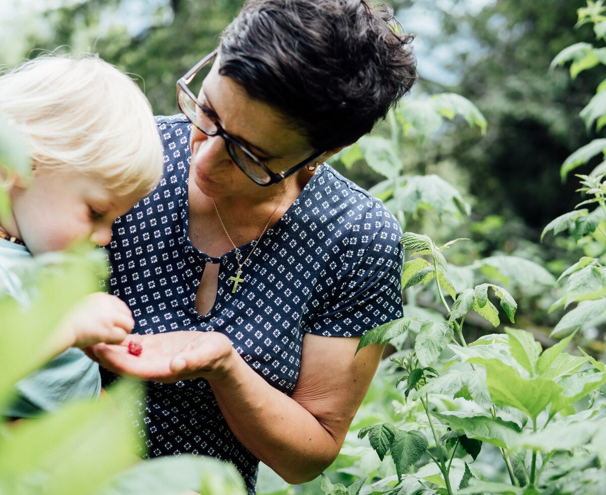 Frau und Kind im Garten beim Strauch | © Urlaub am Bauernhof Kärnten/ Daniel Gollner