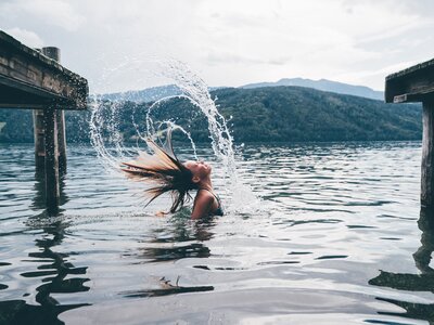 Mädchen im See spritzt das Wasser mit den Haaren | © Urlaub am Bauernhof Kärnten/ Daniel Gollner