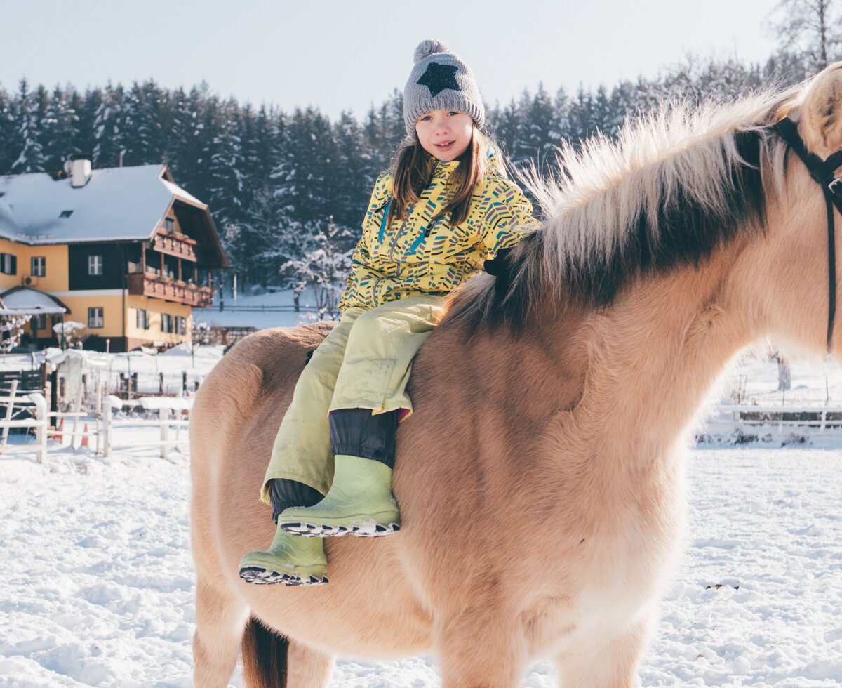 Kind sitzt auf dem Pferd | © Urlaub am Bauernhof Kärnten/ Daniel Gollner