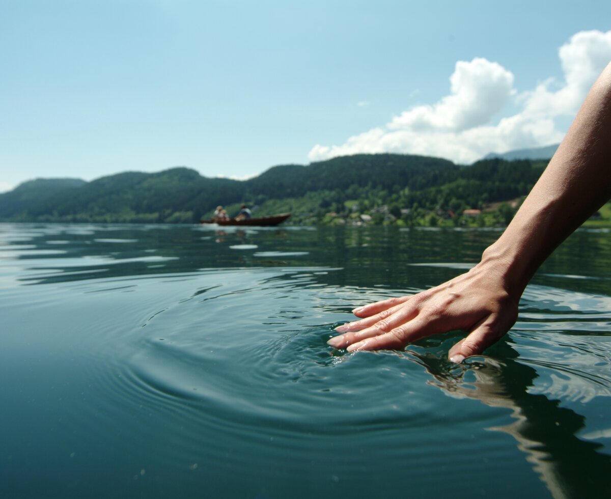 Frauenhand streicht über das Wasser des Sees vom Boot aus | © Steve Haider / Millstätter See Tourismus GmbH