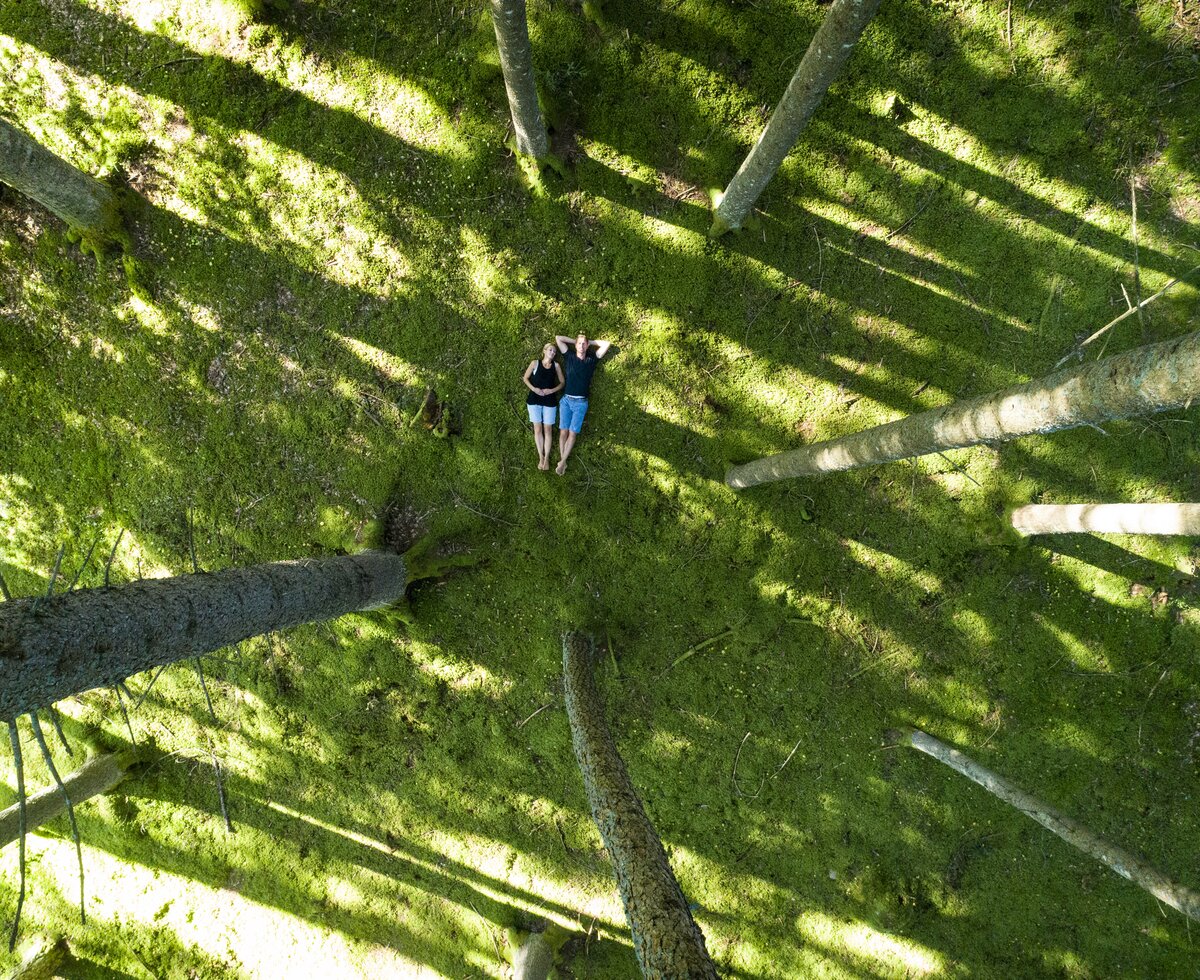 Paar liegt am moosigen Waldboden von oben aus betrachtet | © Gert Perauer / Millstätter See Tourismus GmbH