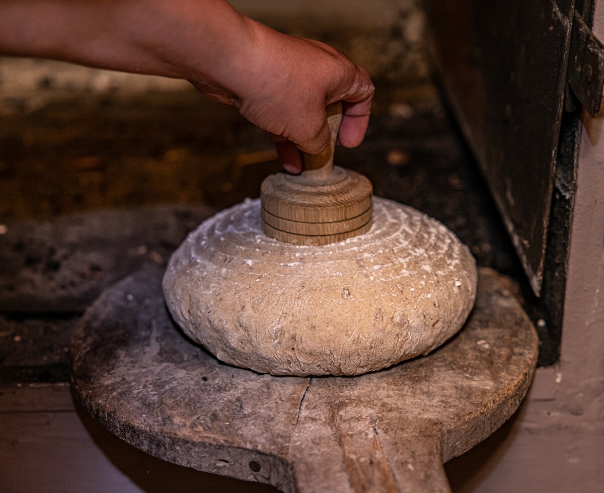 In das rohe Brot wird ein Stempel gedrückt | © Landesverband Urlaub am Bauernhof Kärnten/ Achim Mandler