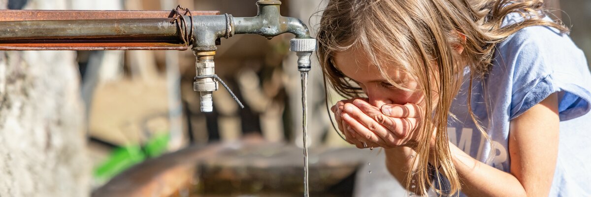 Mädchen trinkt Wasser am Brunnen | © Landesverband Urlaub am Bauernhof Kärnten/ Achim Mandler