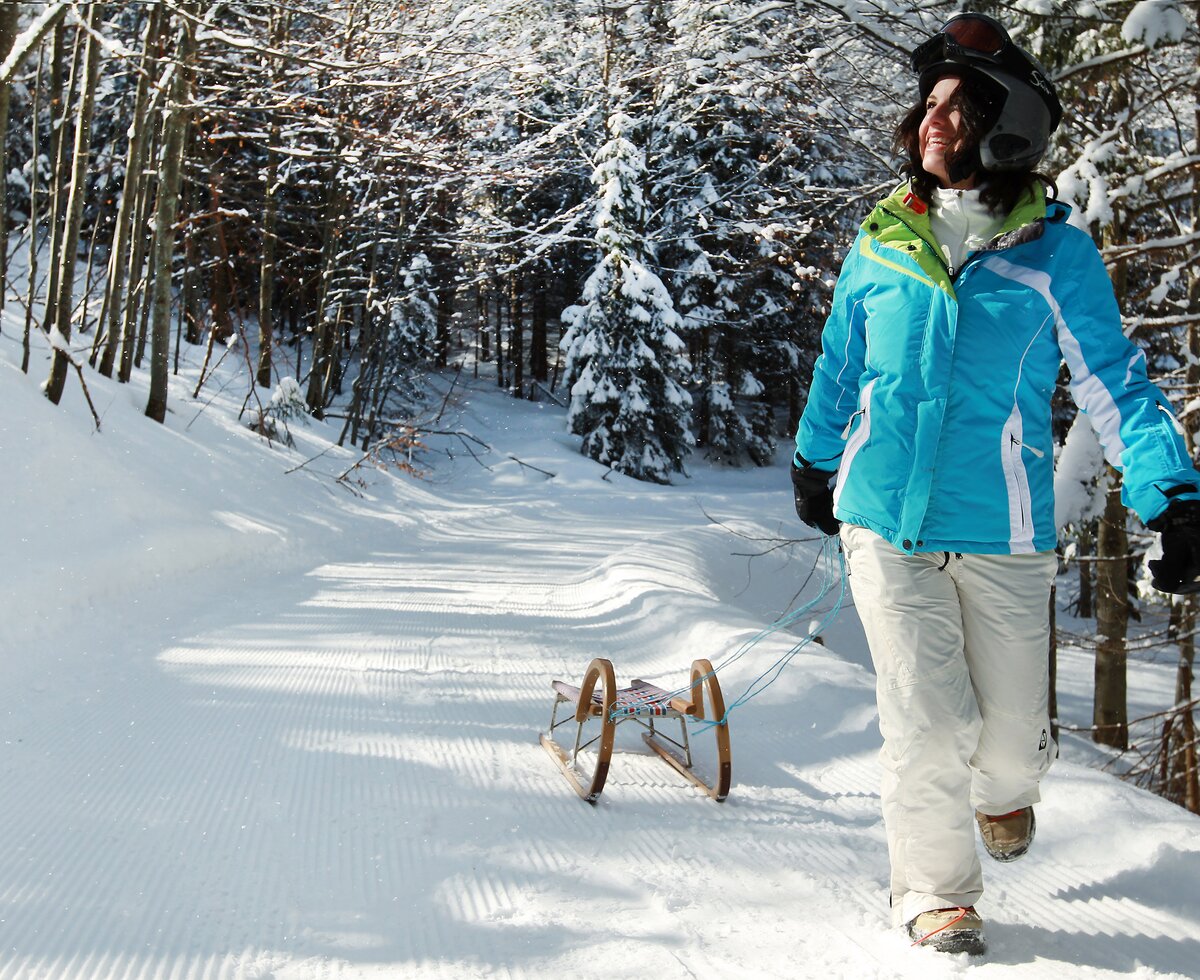 Woman walking with toboggan in winter landscape | © Mostviertel Tourismus / weinfranz.at