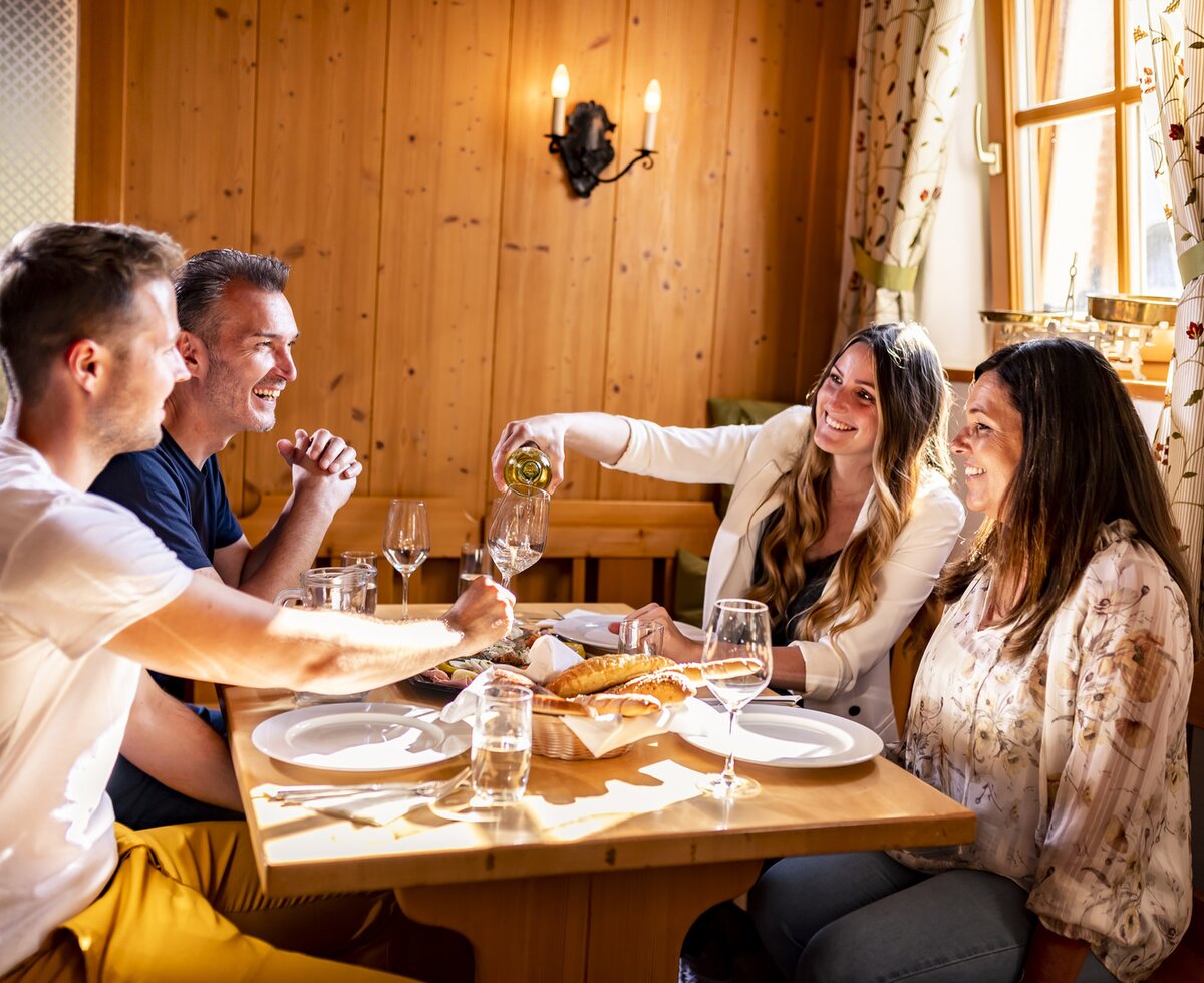 Four people sitting at a table at a wine tavern in the Weinviertel region | © Weinviertel Tourismus / Herbst