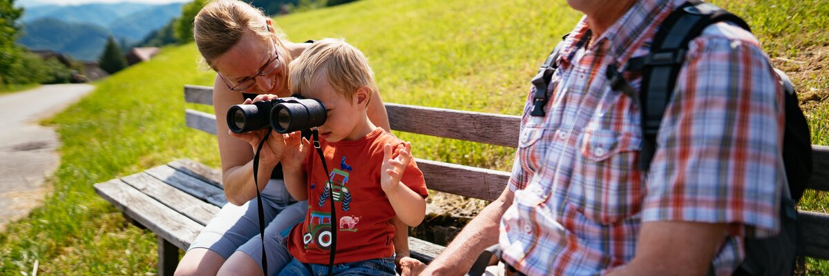 Bub schaut durch das Fernglas in die Natur | © Urlaub am Bauernhof Oberösterreich / Daniel Gollner