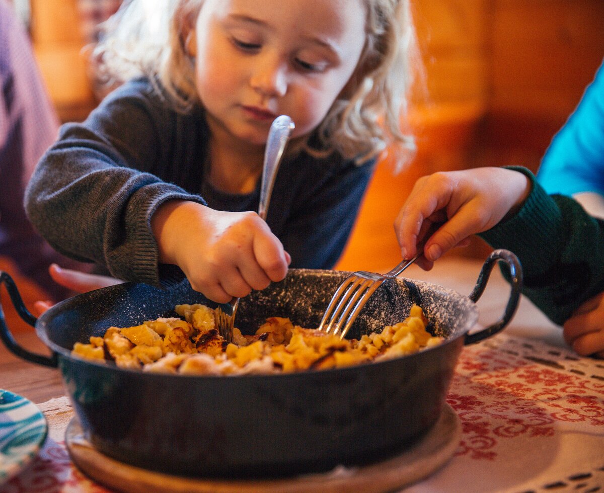 Mädchen isst aus einer Pfanne mit Kaiserschmarren | © Urlaub am Bauernhof Oberösterreich / Pascal Baronit