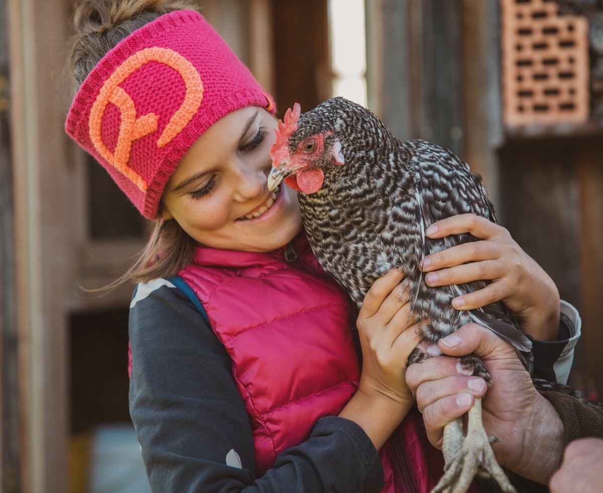 Mädchen mit Huhn in den Armen | © Urlaub am Bauernhof in Österreich / Pascal Baronit