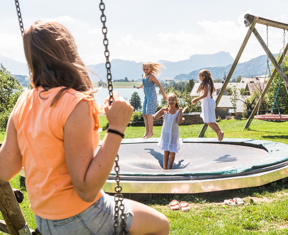 Kinder springen am Trampolin auf dem Spielplatz | © Urlaub am Bauernhof / Punkt und Komma