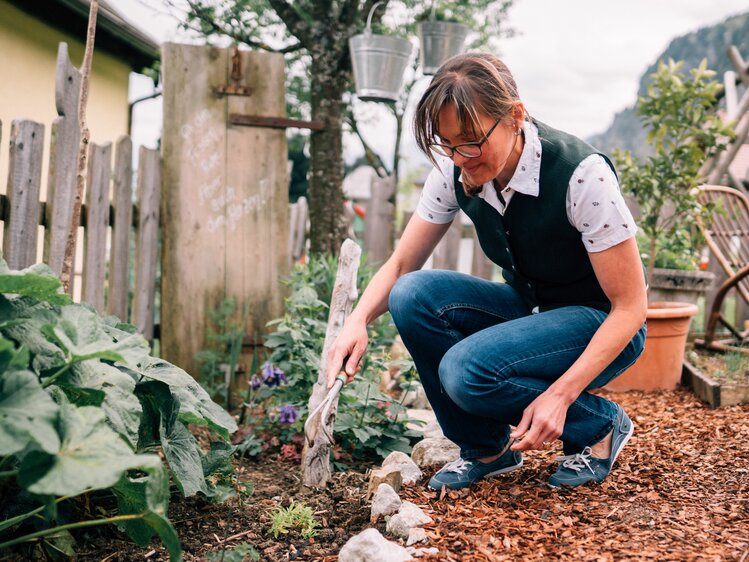 Farmer Sonja Schossleitner from the organic farm Eislbauer works in her farm garden. | © Farmholidays in SalzburgerLand / Daniel Gollner