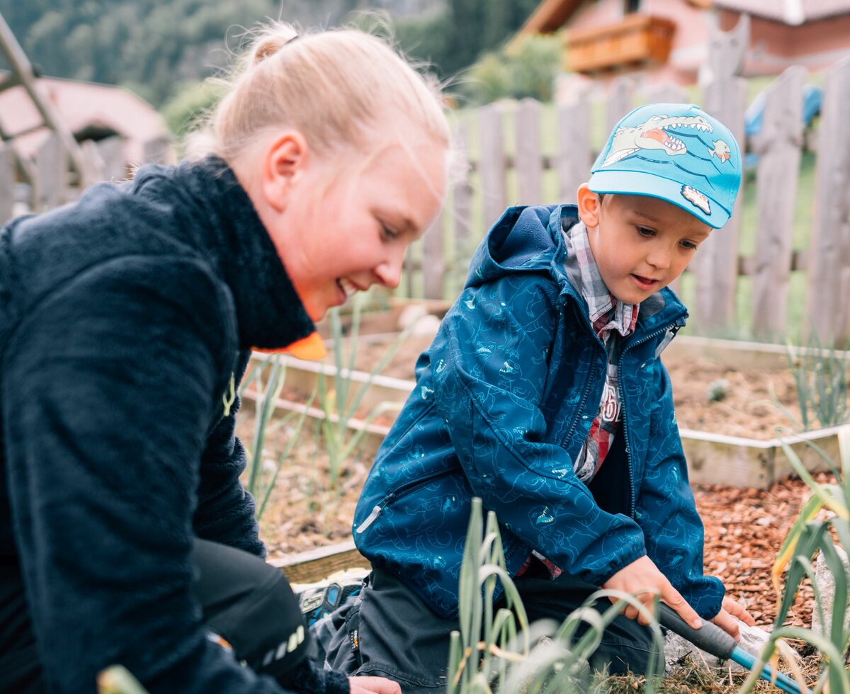 Two children are allowed to help in the garden at the Bio Archehof Eislbauer. | © Farmholidays in SalzburgerLand / Daniel Gollner