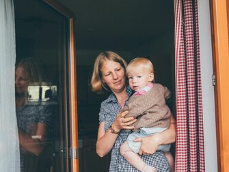 Farmer Kathrin Röck holds her baby on her arm | © Farmholidays in SalzburgerLand / Daniel Gollner