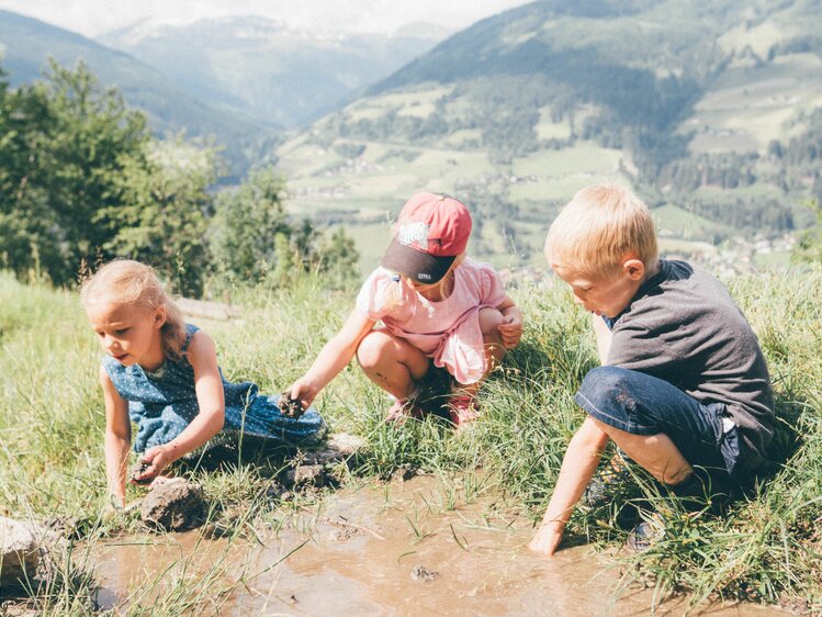 Three children play with water on the alp of Grußberggut in Bad Hofgastein | © Farmholidays in SalzburgerLand / Daniel Gollner