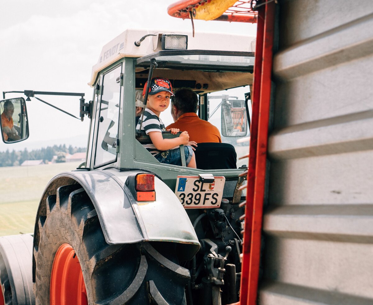 Bub darf mit dem Bauern am Traktor mitfahren. | © Urlaub am Bauernhof im SalzburgerLand / Daniel Gollner