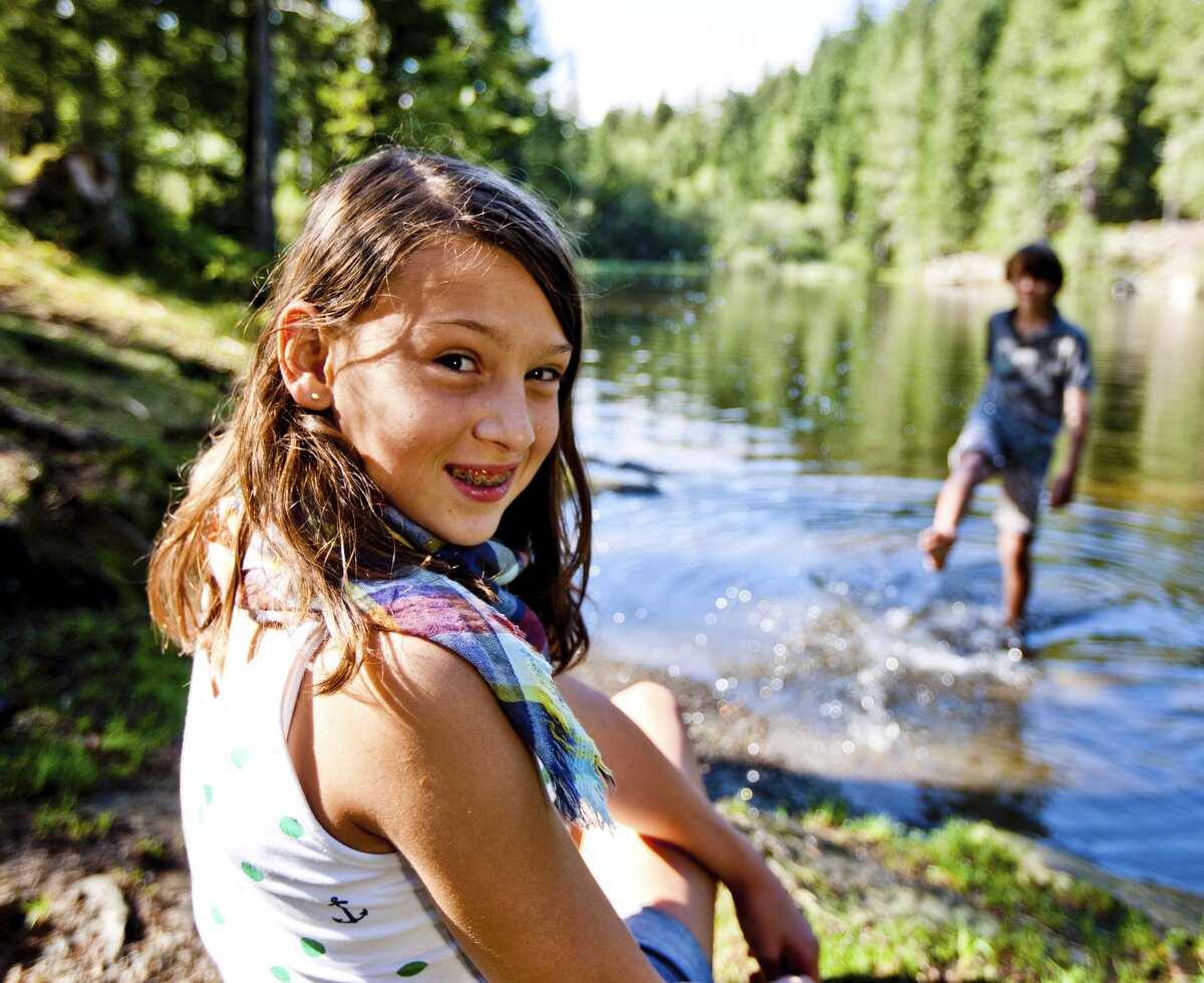 Ein Bub steht im Wasser und das Mädchen sitzt am Ufer, Urlaubsregion Murau-Murtal, Steiermark | © Urlaub am Bauernhof Steiermark / Kufferath