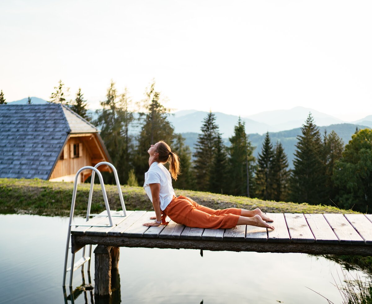 Frau beim Yoga am Badesteg im Urlaub, Almchalet Nikola, Steiermark  | © Urlaub am Bauernhof Steiermark | Daniel Gollner