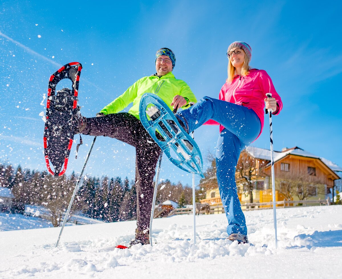 Paar beim Schneeschuhwandern mit dem Bauernhof im Hintergrund, Urlaubsregion Murau-Murtal, Steiermark | © Urlaub am Bauernhof Steiermark / Wolfgang Spekner