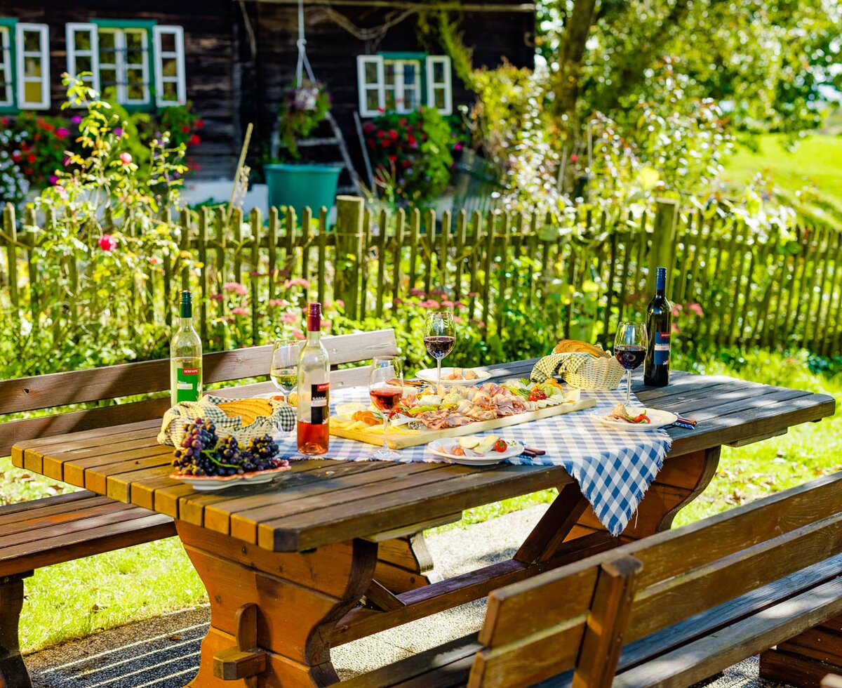 Brettljause mit Wein im Buschenschank im Freien ohne Menschen, Süd-West-Steiermark, Steiermark | © Urlaub am Bauernhof Steiermark / Wolfgang Spekner