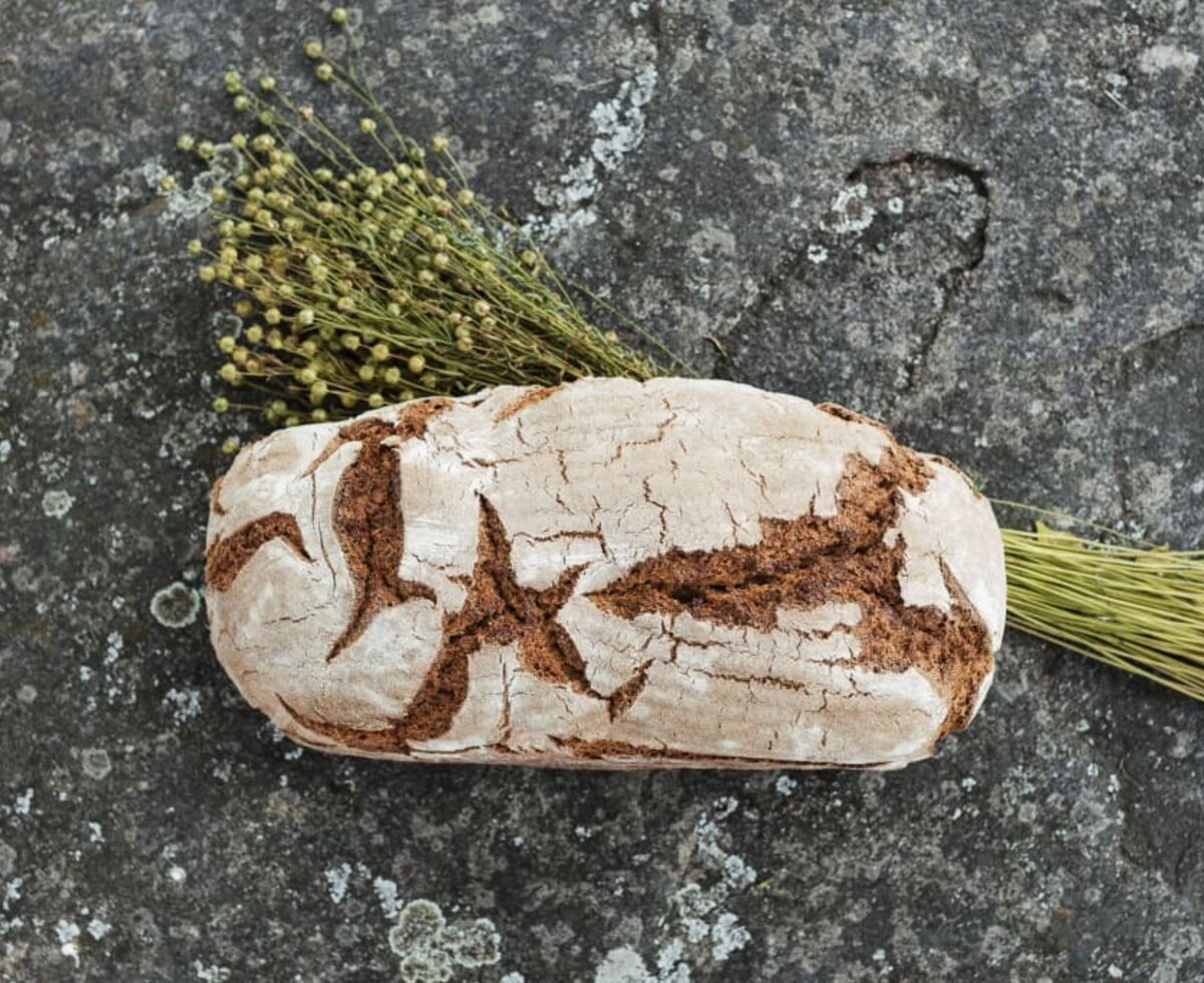 Frisch gebackenes Brot liegt mit Gemeinem Lein auf einer Granitplatte | © Urlaub am Bauernhof Oberösterreich / Biohof Schafflhof