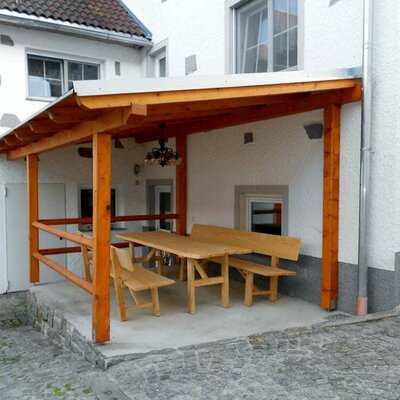 Covered seating area with table in the inner courtyard at the Fuchsnhof.