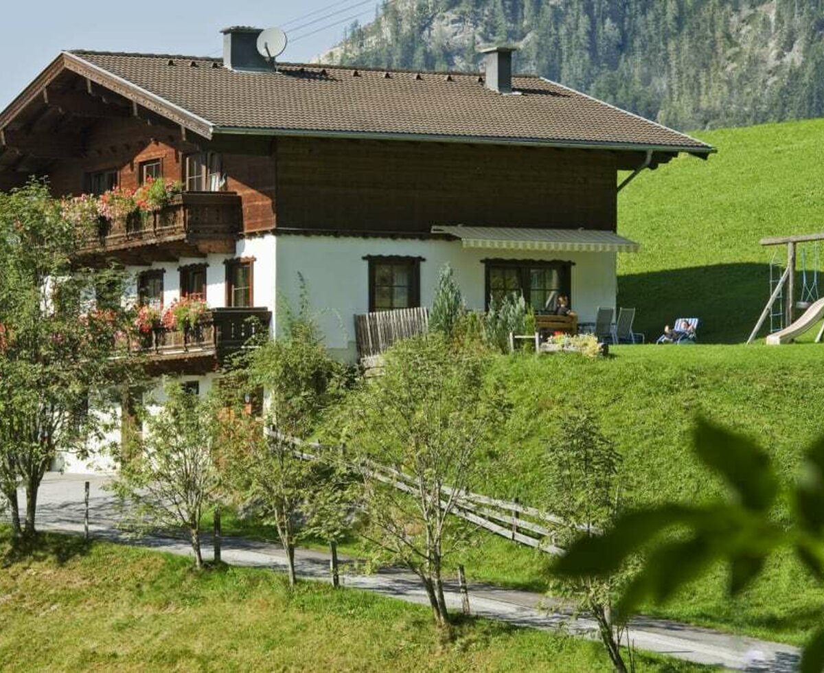 Our holiday home in summer with adjacent sun terrace. Perfect for relaxing - the playground, barbecue area and sunbathing area!