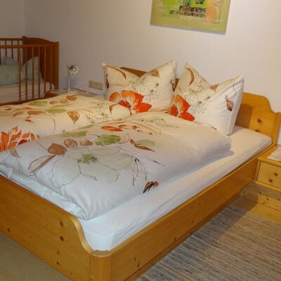 Bedroom with baby cot and bunk bed.